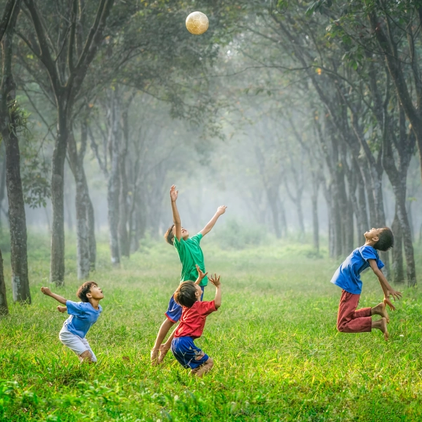 Group of children jumping and playing in woods